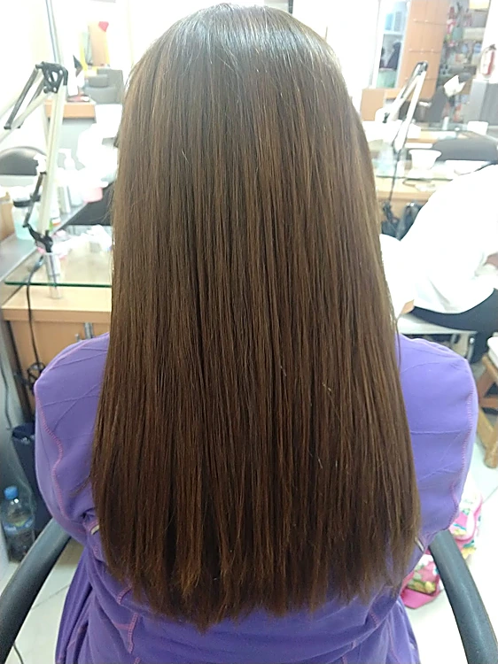 Cabello castaño largo y liso, de espaldas, después de un alaciado