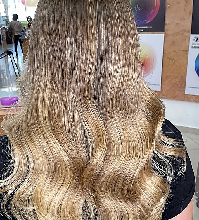Cabello largo en balayage rubio con ondas suaves, de espaldas